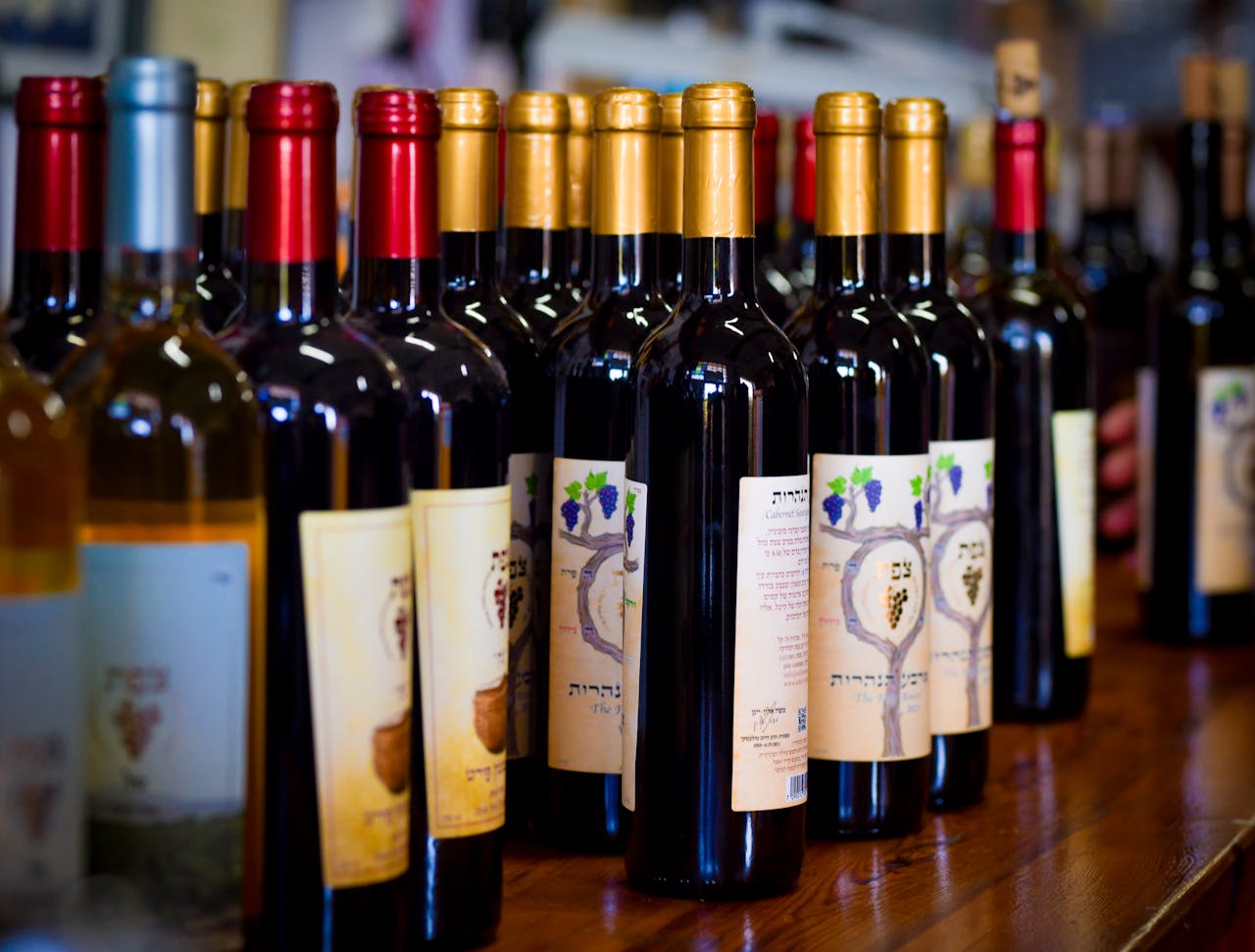 why-choose-us Close-up of assorted wine bottles on display at a winery showcasing various labels and colors.