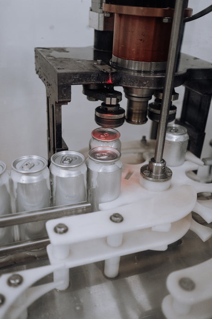 Services-01 Close-up of beverage cans on an automated assembly line in a factory.